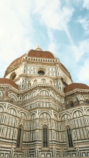 The marble-clad dome and facade of a grand cathedral seen from below