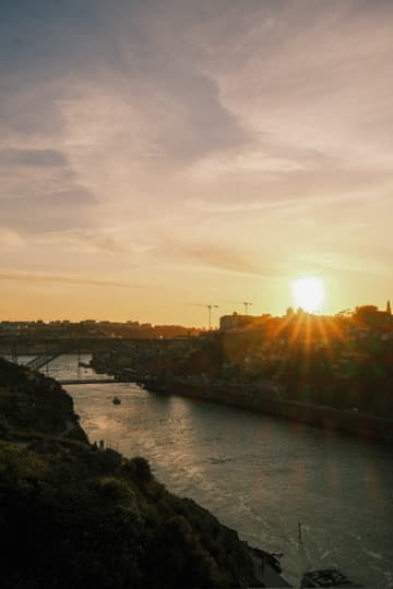 The sun setting over the Douro river, with bridges silhouetted against an orange sky