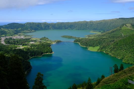 Twin crater lakes, one blue and one green, seen from the rim above